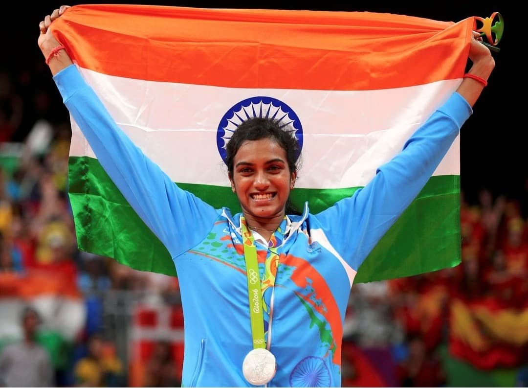 P. V. Sindhu with her Rio 2016 Olympic silver and the Indian flag. Ten years later in Tokyo, she became the first Indian women’s singles champion at the Japan Open.