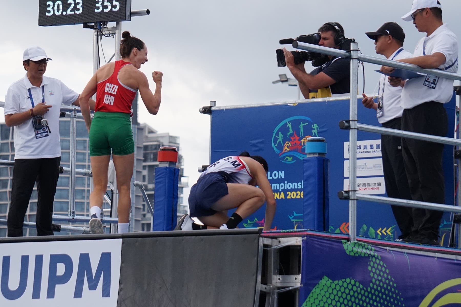 Seong Seung-min (white kit) after the women's final at the 2026 UIPM World Championships in Guiyang, with Hungary's Blanka Guzi celebrating.